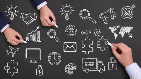 Top view of business people hands drawing business strategy plan on blackboardの素材