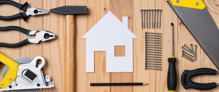 Home improvement concept. House model, tools and instruments on wooden backgroundの素材