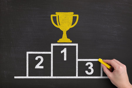 Winner's podium drawn with yellow chalk on blackboard, success conceptの素材