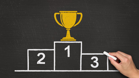 Chalk drawing winner's podium with gold trophy on blackboard backgroundの素材