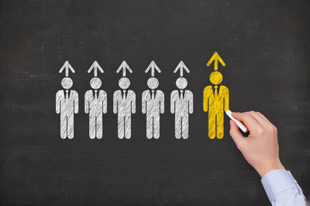 Businessman drawing a group of people with a chalk on a blackboardの素材