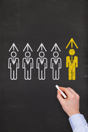 Businessman drawing group of people on blackboard. Teamwork conceptの素材