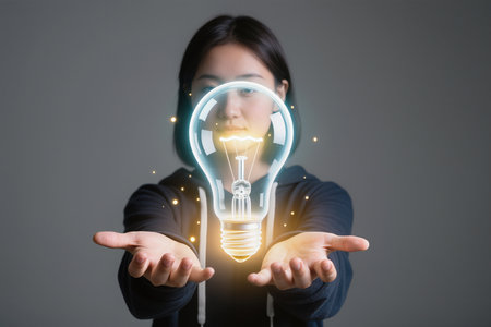 Businesswoman holding light bulb in her hand. Concept of idea.の素材