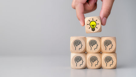 Wooden blocks with symbol of idea and brain icon over grey backgroundの素材