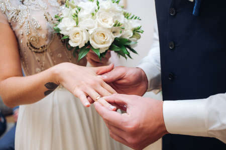 Croped Bride and groom with wedding rings at ceremony exchangeの写真素材