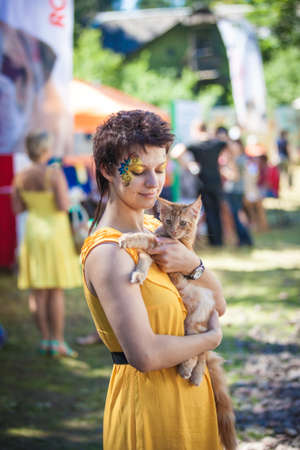 Close up portrait of a girl holding adorable maine coon kitten, and smilingの写真素材