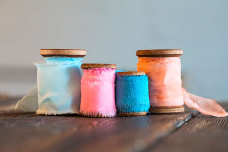 Colored coils of colored cotton ribbons on wooden surface.の写真素材