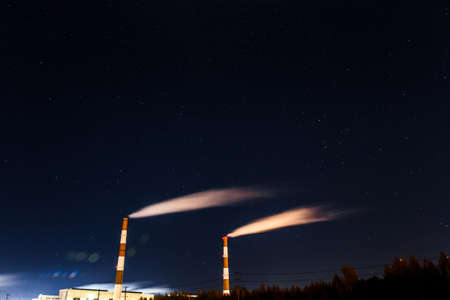 Energy. Smoke from chimney of power plant or station. Industrial landscape at night at long exposureの写真素材
