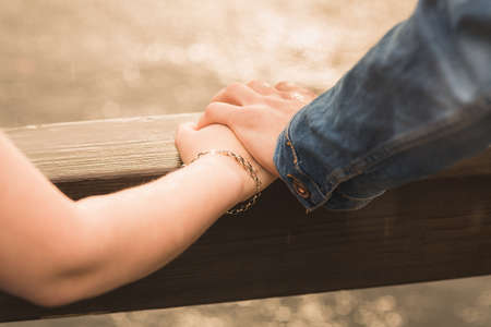 Male and female hands touching. Closeup, shallow DOFの写真素材
