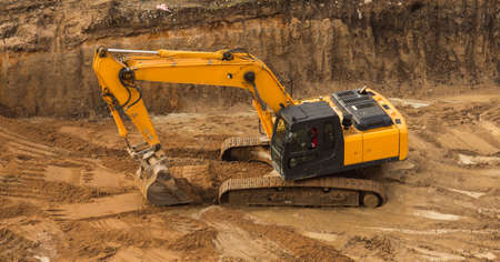 View from above at Working Excavator Tractor Digging A Trench.