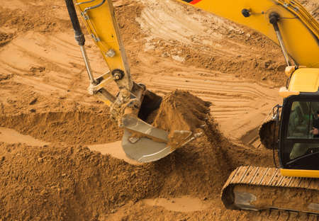 View from above at Working Excavator Tractor Digging A Trench.の写真素材