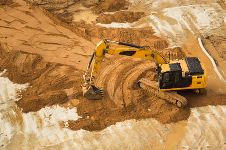 View from above at Working Excavator Tractor Digging A Trench.