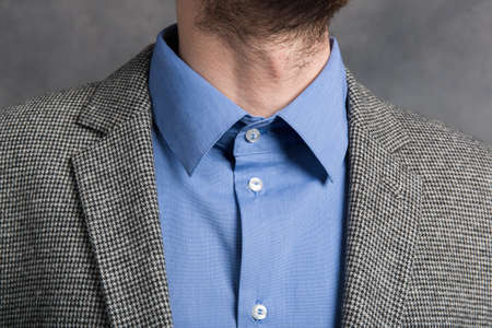 Close-up view ata collar of a man in blue shirt and checkered blazer Cropped shot of businessman in...