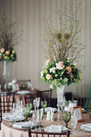Beautiful composition with flowers on the tables and candles for guests at a wedding or a birthday party.の写真素材