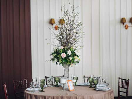 Beautiful composition with flowers on the tables and candles for guests at a wedding or a birthday party.の写真素材