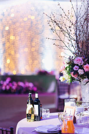 Beautiful composition with flowers on the tables and candles for guests at a wedding or a birthday party.の写真素材