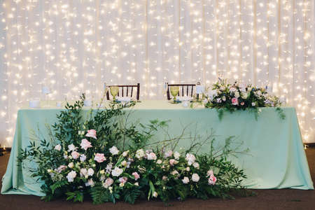 View at a table of bride and groom. Beautiful composition with flowers on the tables and candles for...