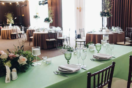 Beautiful composition with flowers on the tables and candles for guests at a wedding or a birthday...
