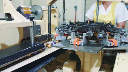 Candy factory. Industrial machine wrapping candies. Modern industrial machine wrapping tasty sweets and putting them on conveyor on confectionery factory.の写真素材