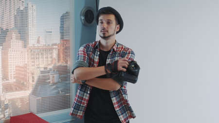 Handsome photographer posing for somebody taking photos with smartphone. He smiling and having fun during photo shoot.の写真素材