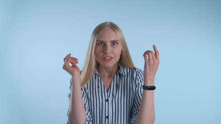 Cheerful blonde woman coming to an excellent idea after a minute of thinking on blue background.の写真素材