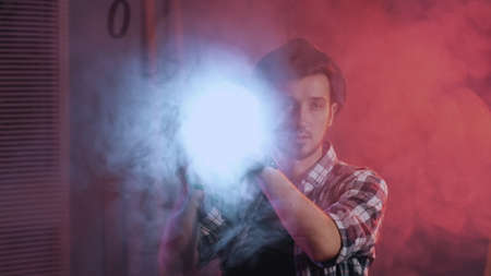 Close-up of technicians in the filmmaking lighting the lamp and smiling to the camera. There is red...