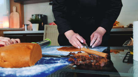 Woman showing her child how to make gingerbread cookies. Family culinary and traditions concept.の写真素材