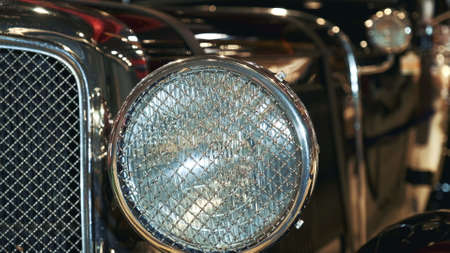 Close-up view of black vintage car headlight with chrome bezelの写真素材