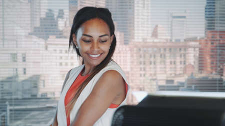 Close-up of black model posing on camera during professional photo shoot in studio. In the background there are skyscrapers.の写真素材