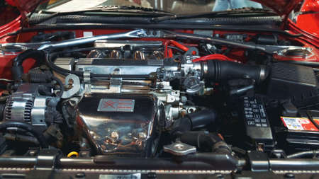 Under the retro car hood: generator, engine, air filter, battery. Polished and shiny elements