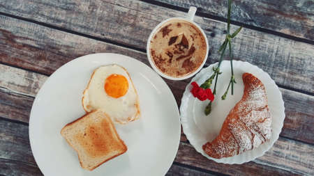 Light tasty breakfast with a cup of coffee: fried egg, toast and croissantの写真素材
