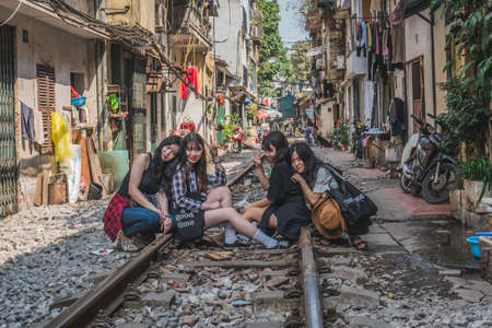Girls take photos on railway tracks. Hanoi, Vietnam - March 2, 2020.のeditorial素材