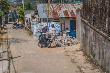 Girls carry bricks on a motorcycle. Dalat, Vietnam - March 17, 2020のeditorial素材