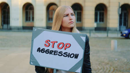 Protest walk: woman protesting to stop aggression by holding steamer. She is upset by what is happening in the world.の写真素材