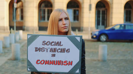 Womans protest walk with steamer against social distancing that equals communism. Close-up shot.の写真素材