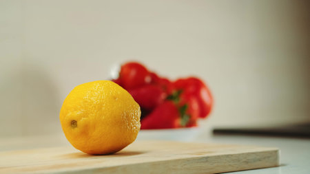 Close-up shot of hands with knife cutting lemon on the kitchen board.の写真素材
