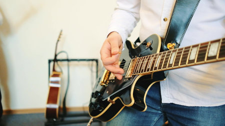 Close up of man playing guitar. Concert with a bandの写真素材