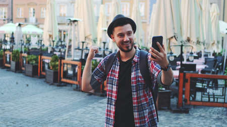 Tourist making video call on smartphone and showing his place of visit. Sightseeing in beautiful european city.の写真素材