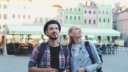 Young couple of tourists using smartphone and admiring beautiful surroundings. They going sightseeing early in the morning.の写真素材