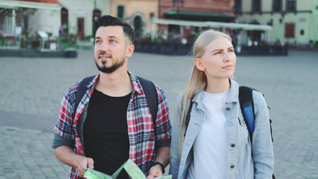 Man and woman with map looking for new historical place in city center. They walking and finding something interesting.の写真素材