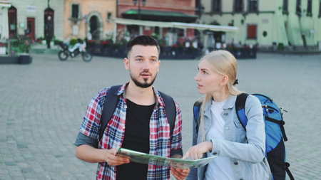 Young couple of tourists with map looking for new historical place in city center. They walking and finding something interesting.の写真素材