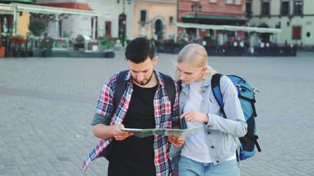 Young couple of tourists with map walking and looking for new historical place in city center. They walking and finding something interesting.の写真素材