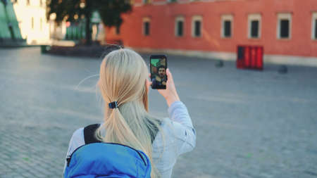 Female tourist making video call on smartphone with her friend from other place. They exchanging impressions from travelings.の写真素材