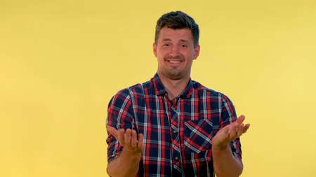 Good-looking man is stunned by the good news. There is yellow background.の写真素材