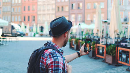 Medium shot of tourist making video call on smartphone with female tourist from other place. They exchanging impressions from travelings.の写真素材