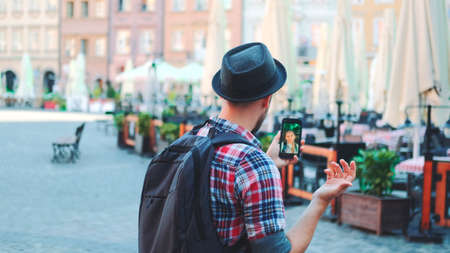 Tourist making video call on smartphone with female tourist from other place. They exchanging impressions from travelings.の写真素材
