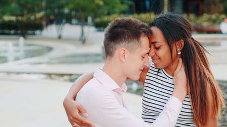 Happy multiethnic couple having romantic date in a beautiful place outdoors. Relationship concept.の写真素材