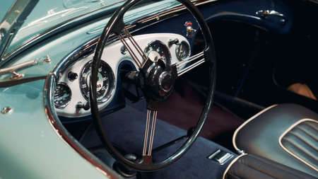 View of instrumental panel and wheel of retro car. Black leather car sits. Warsaw, Poland - July 10, 2019のeditorial素材