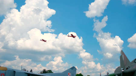 Two small airplanes flying thorough the sky. A mixture of clouds and blue sky provides a great backdrop.の写真素材