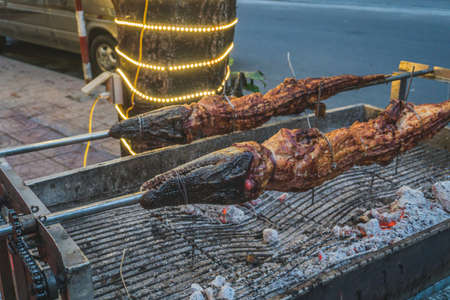 Grilled crocodile on the open fire at sea food restaurant, exotic meals in Viethnam, food of the asian cuisine, raw crocodile meat, exotic food.の写真素材